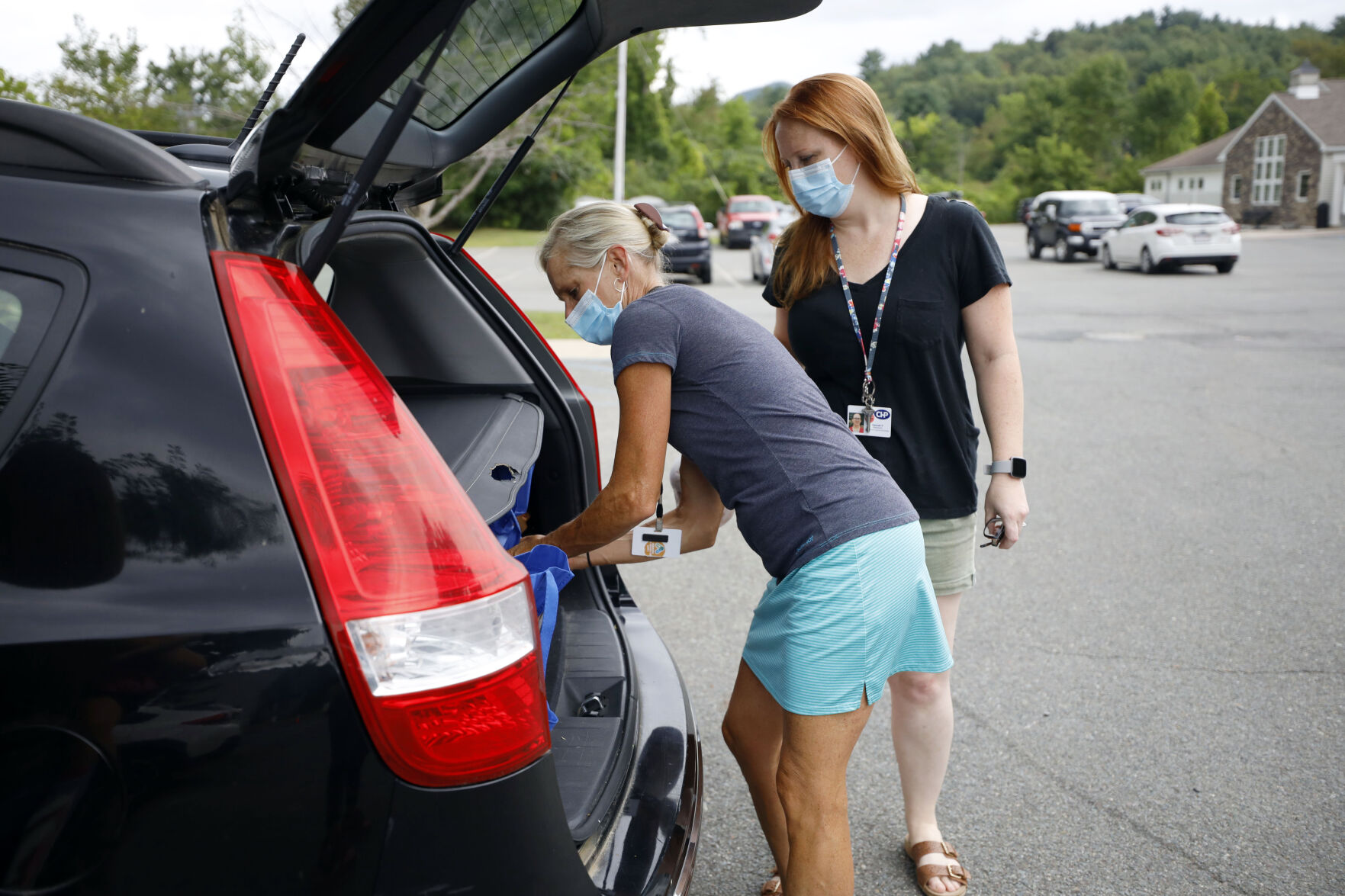 Ashli Minor and Hannah Paterson load grocery bags into car